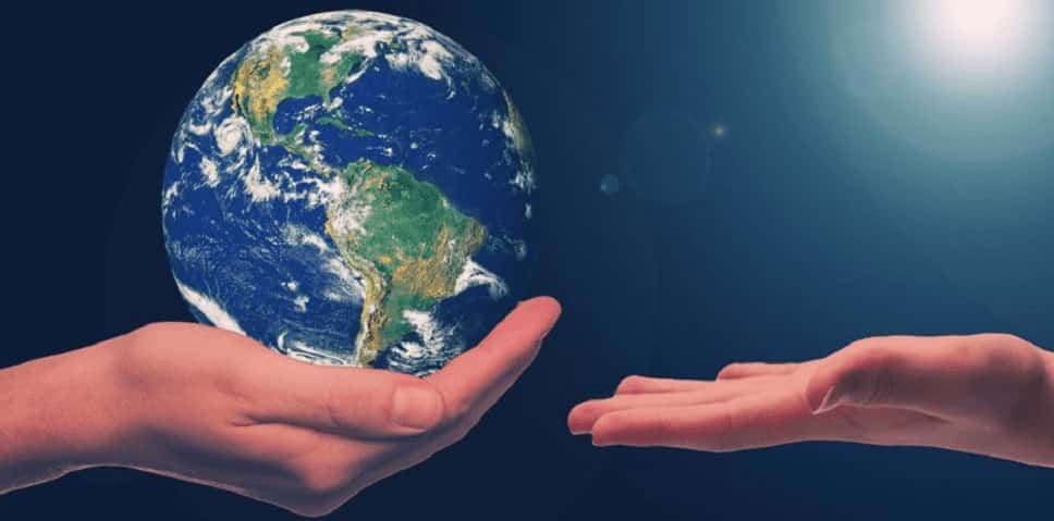 Une main porte la planète Terre, symbole de l'importance d'organiser un séminaire d'entreprise écologique