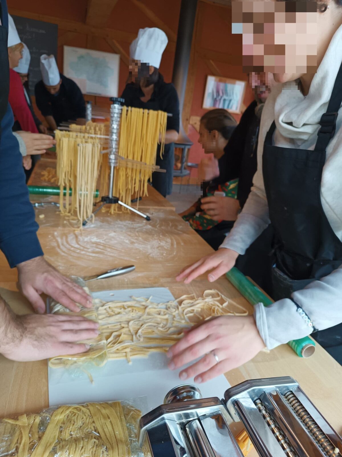 des collègues préparent leur propre repas au cours d'un team-building pasta party, atelier de cuisine italienne