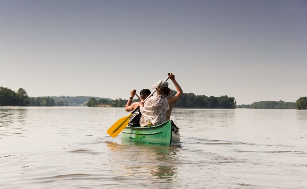 2 collègues font du canoé sur la Loire, un team-building organisé pendant leur séminaire en France à Family Ecolodge