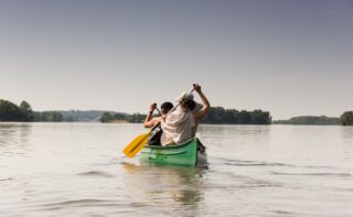 2 collègues font du canoé sur la Loire, un team-building organisé pendant leur séminaire en France à Family Ecolodge