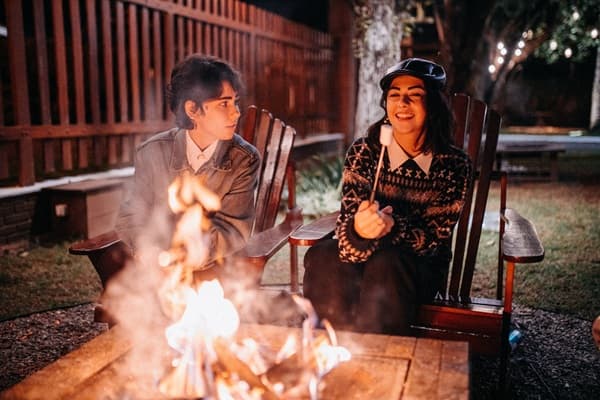 deux collègues discutent autour d'un feu de camp.