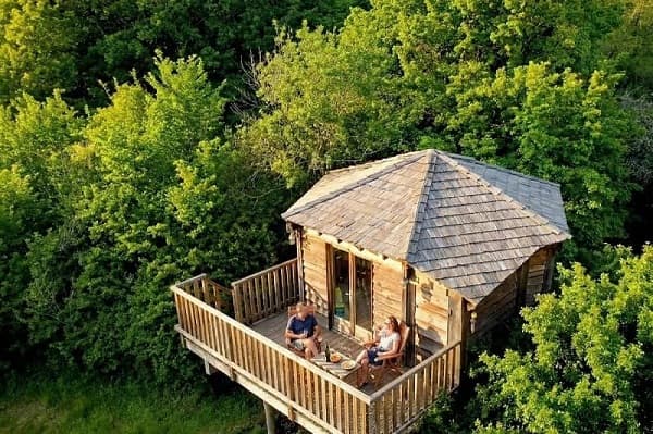 vue aérienne d'une cabane perchée dans les arbres, hébergement insolite durant un séminaire à Family Ecolodge .