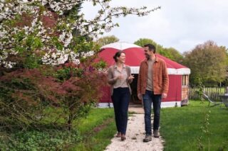 Deux collaborateurs discutent chaleureusement devant une yourte durant un séminaire comme à la maison.