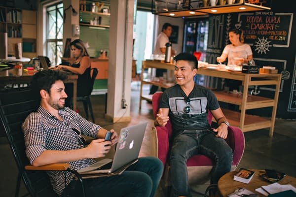 Un groupe de collaborateurs discute dans une ambiance décontractée durant un séminaire de start-up chaleureux et réussi.